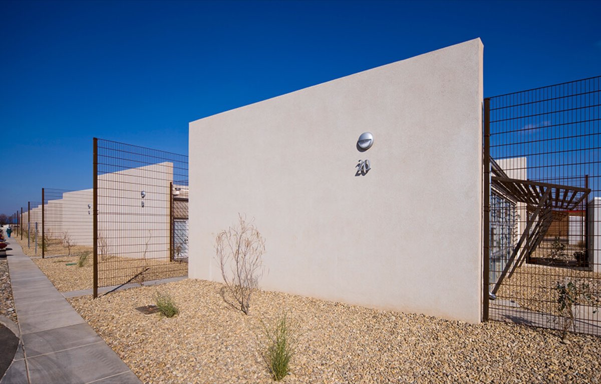 Single-story stucco apartment homes with gravel yards and privacy fencing at Lo Lomas, Clovis NM