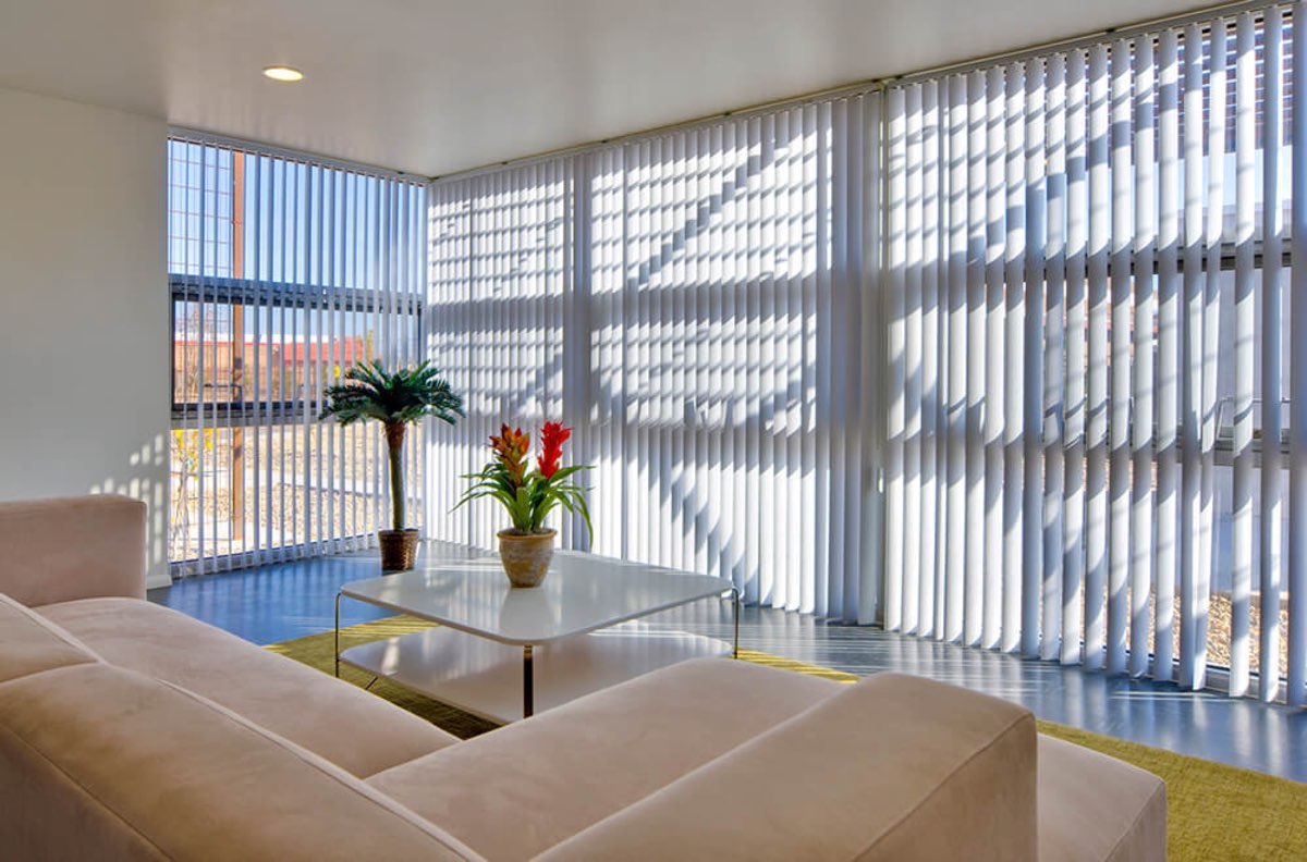 Sunlit community great room at Lo Lomas with lounge seating and floor-to-ceiling windows